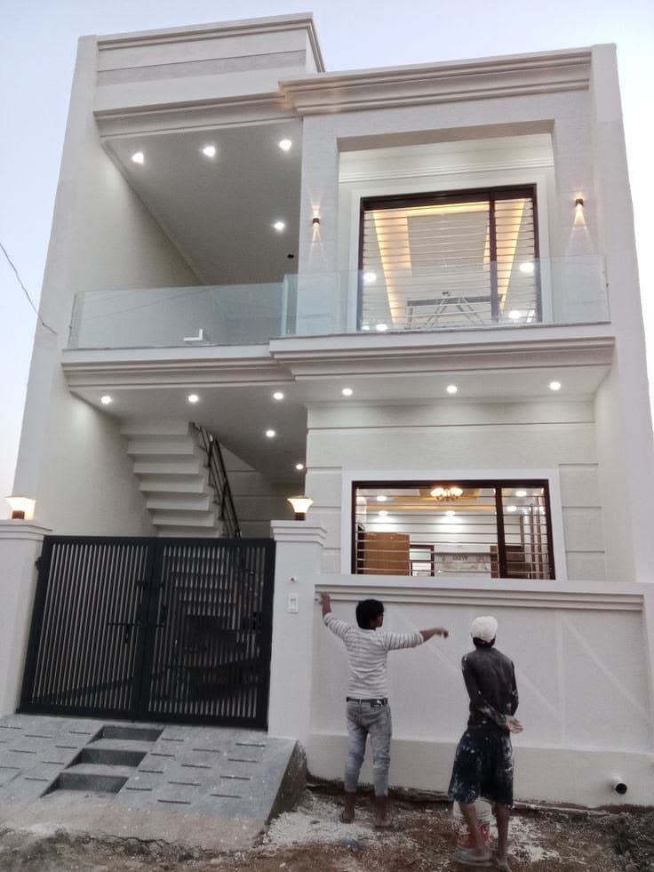 Two painters on a ladder applying a fresh coat to the white facade and parapet of a multi-storey house